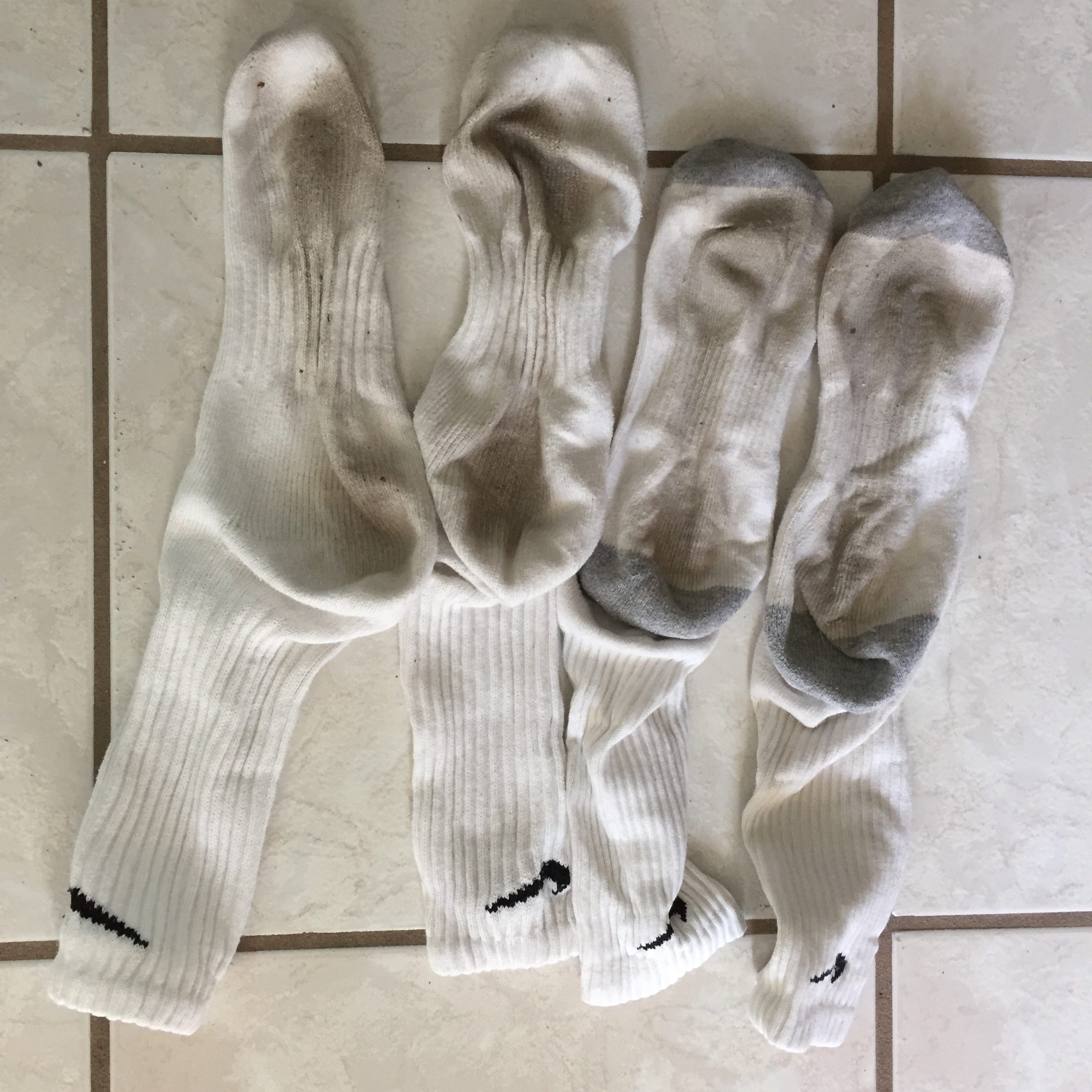 a group of white socks on a tile floor