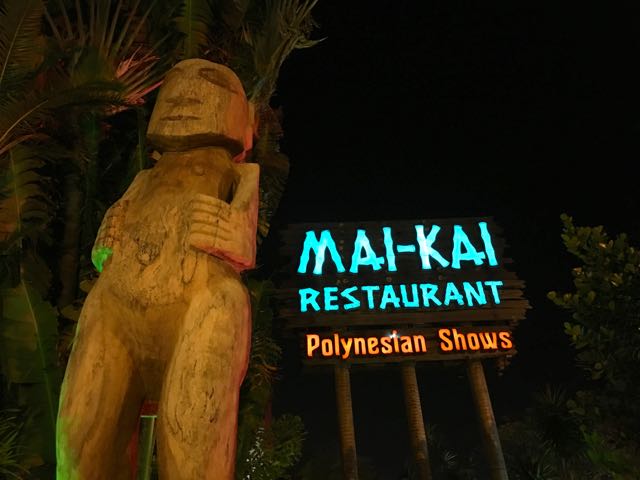 a sign with a statue in front of it