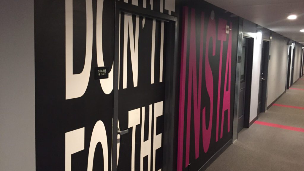 a door with a black frame and pink letters on the wall