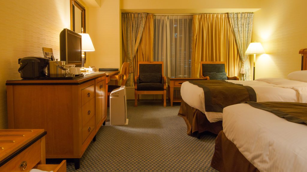 a room with two beds and a television