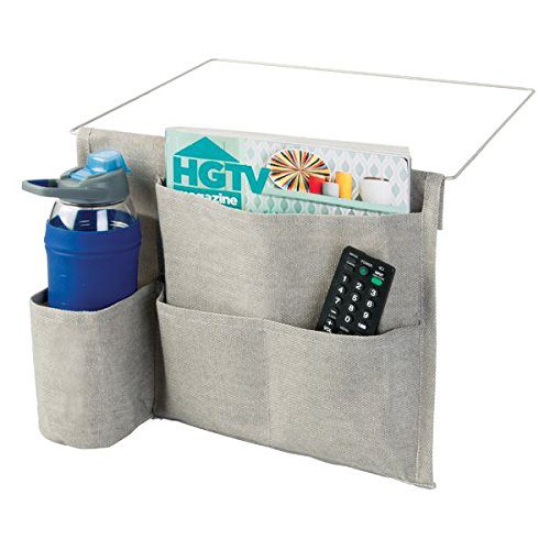 a grey fabric organizer with a remote control and magazine