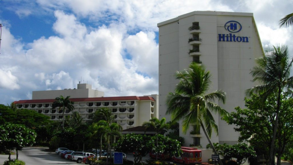 a building with palm trees and a blue sky