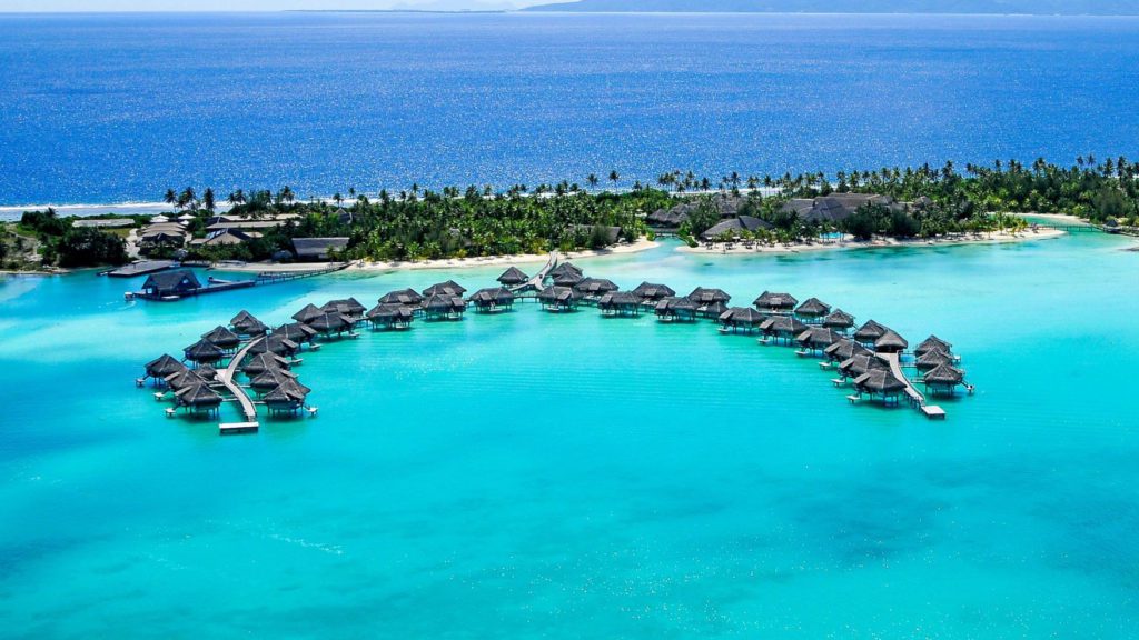 a group of huts in a circle in the water