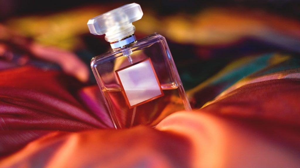 a bottle of perfume on a red fabric