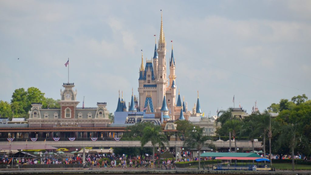 a castle with many towers and people walking in front of it