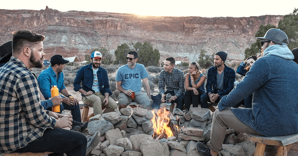 a group of people sitting around a fire