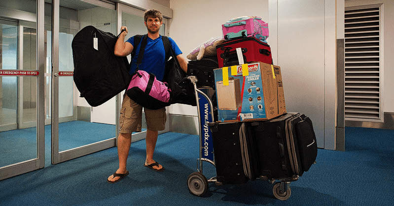 a man standing next to a cart of luggage