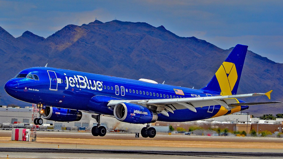 a blue and yellow airplane taking off