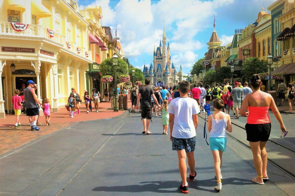 a group of people walking on a street with a castle in the background