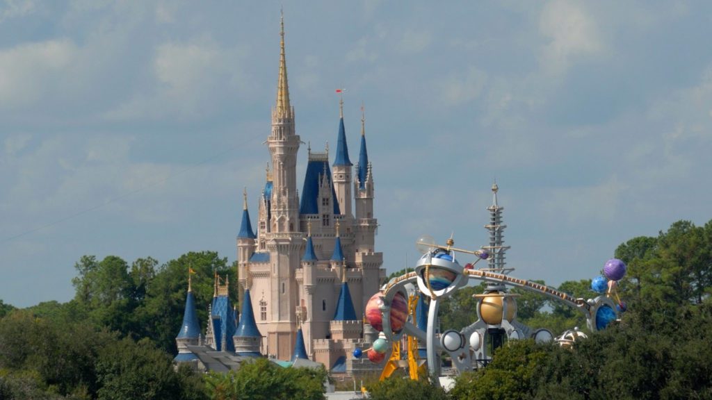 a castle with blue towers and a roller coaster