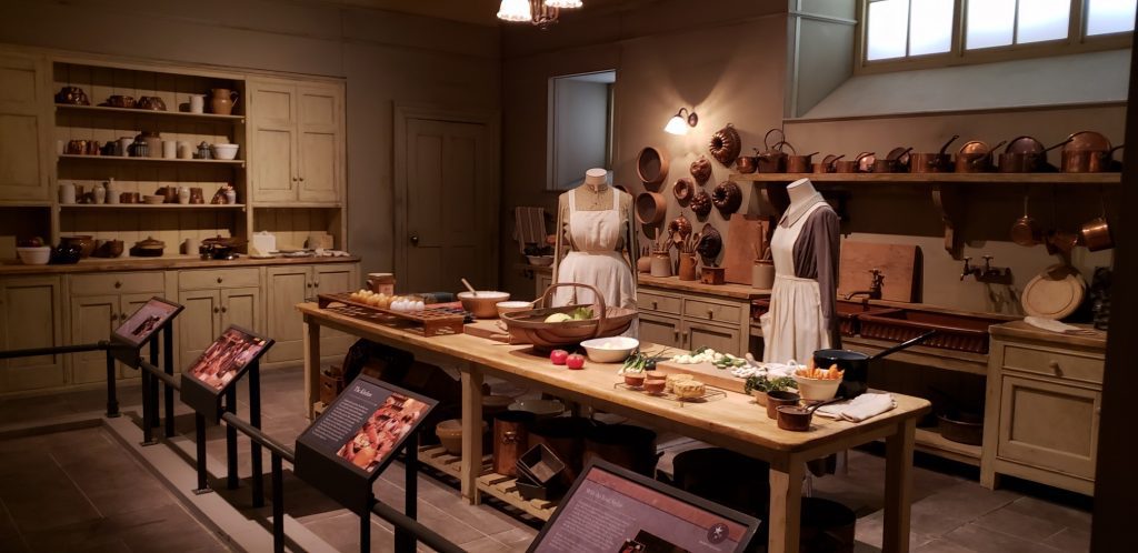 a kitchen with mannequins and food on the counter