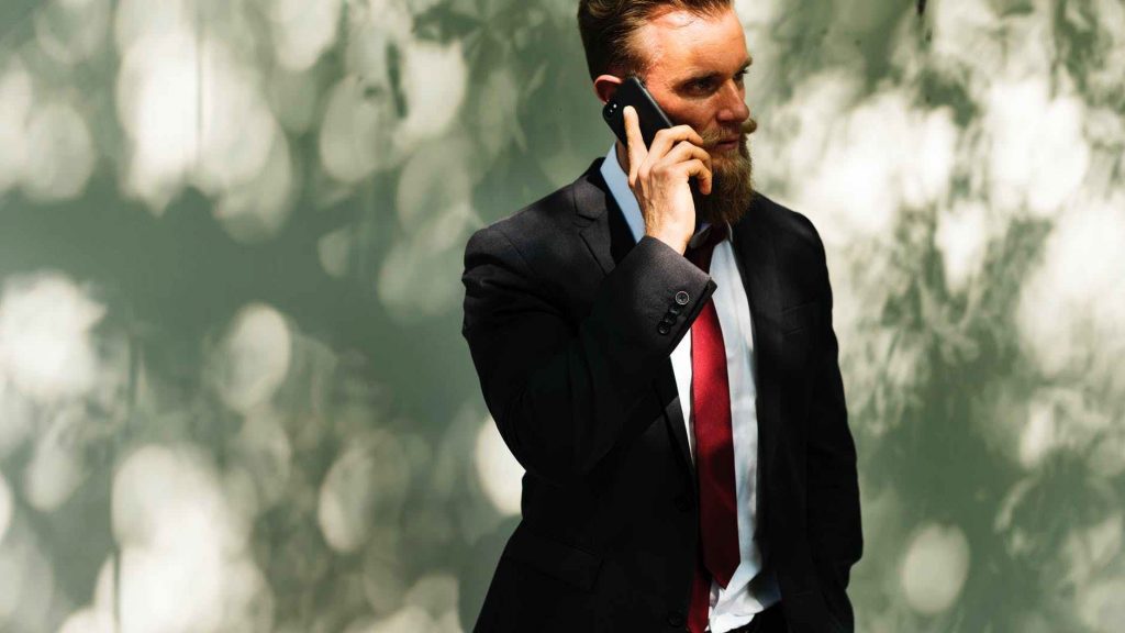 a man in a suit talking on a cell phone