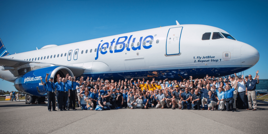 a group of people posing for a photo in front of a jet