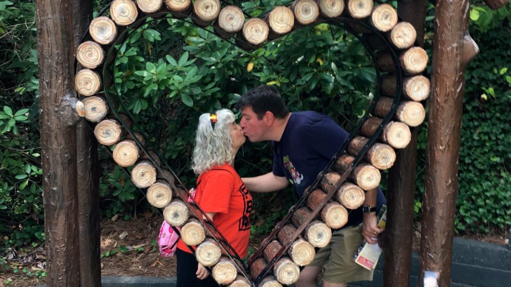 a man and woman kissing in a heart shaped object