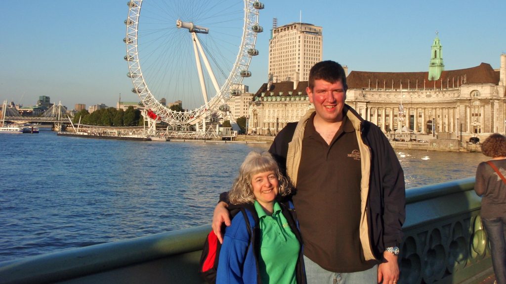 a man and woman standing in front of a ferris wheel