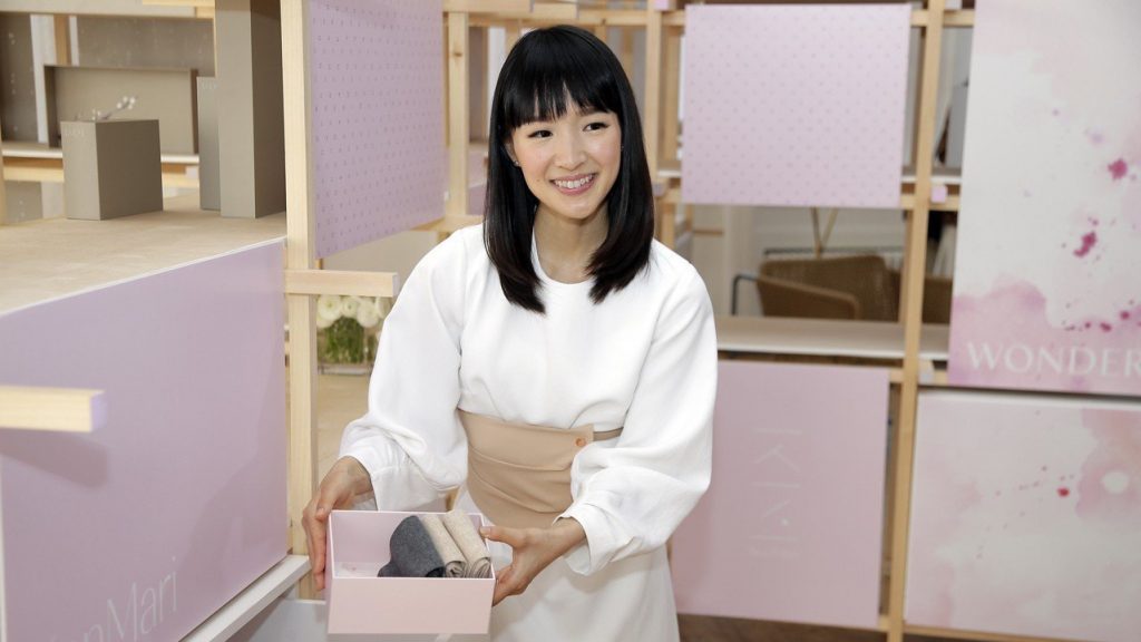 a woman holding a box of clothes