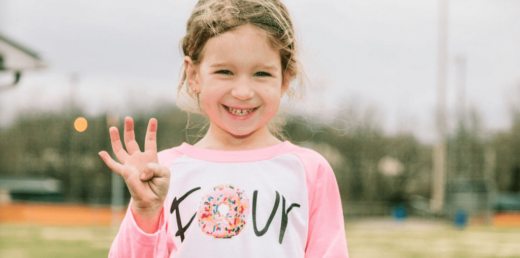 a girl smiling with a peace sign