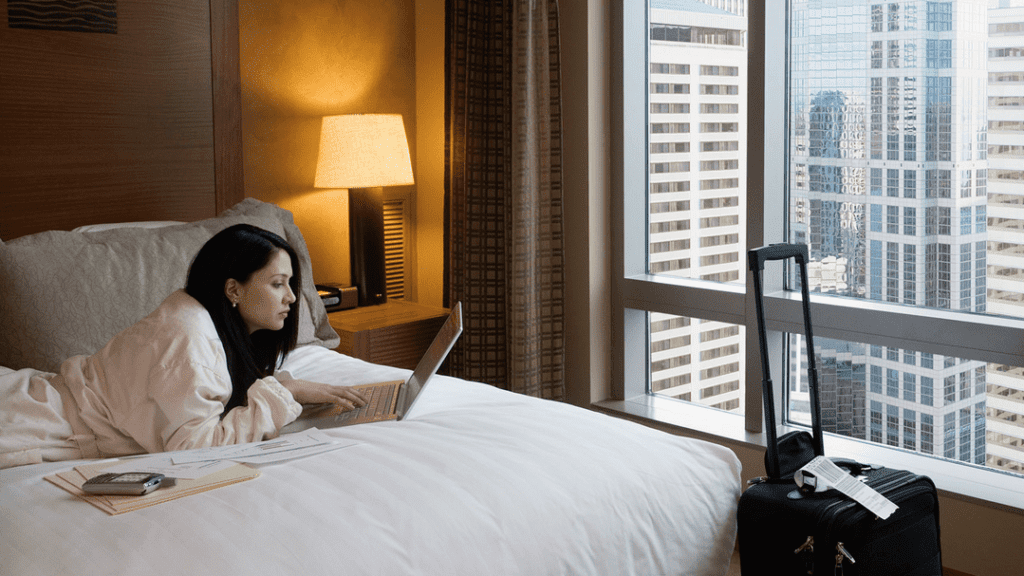 a woman sitting on a bed with a laptop