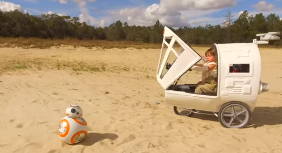 a child in a car with a robot in the sand