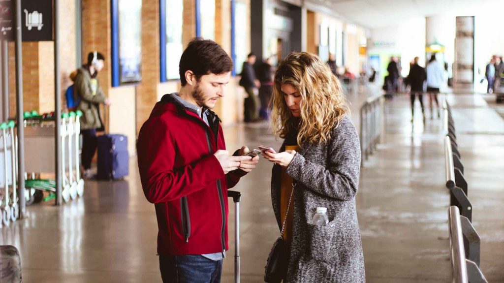 a man and woman looking at their phones