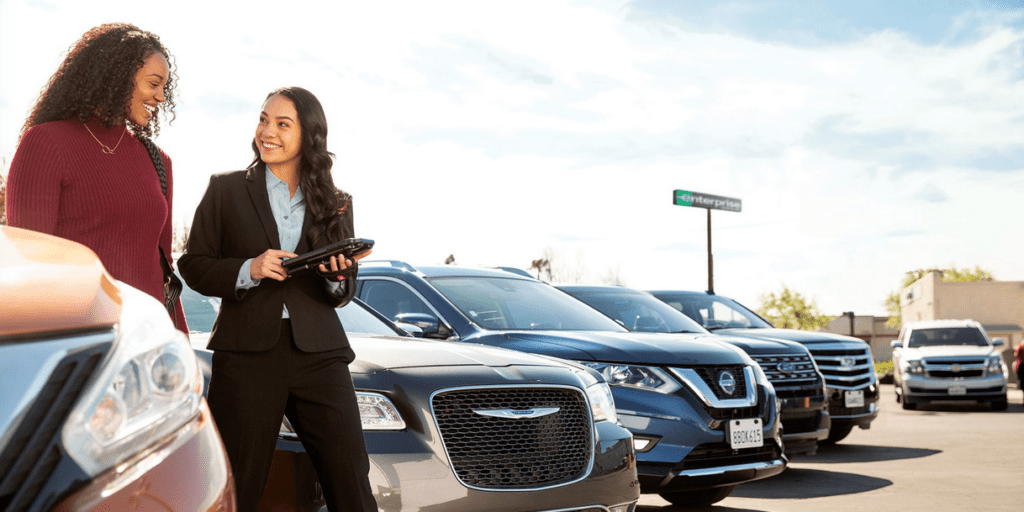 a woman standing in front of a row of cars