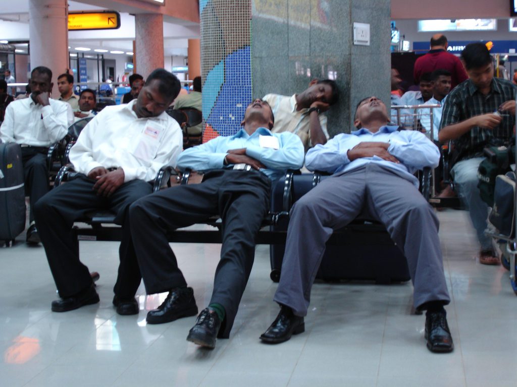 a group of men sleeping in a waiting room