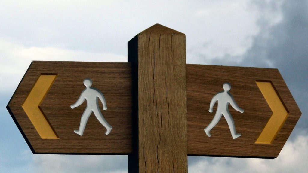 a wooden sign with people carved on it