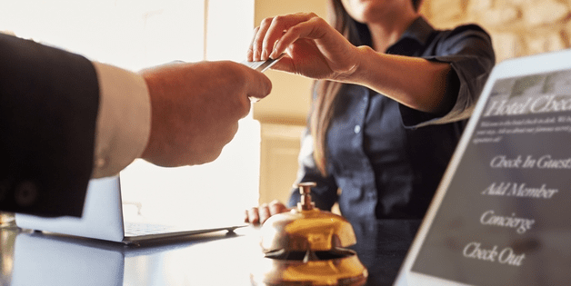 a close-up of a man handing a credit card to a woman