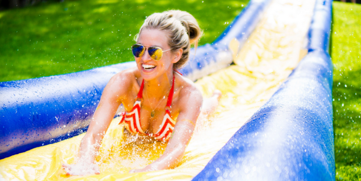 a woman in a garment and sunglasses on a water slide