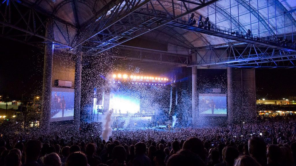 a large crowd of people in a large building with a stage and lights