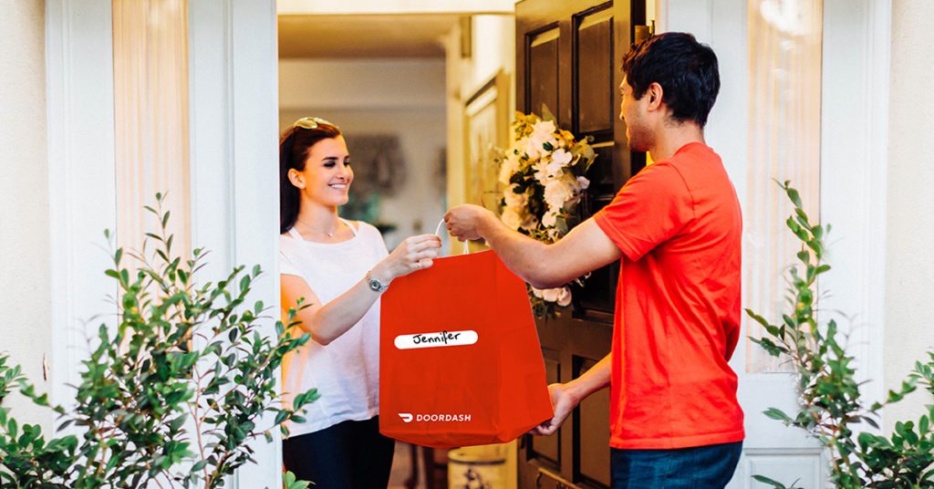 a man handing a red bag to a woman