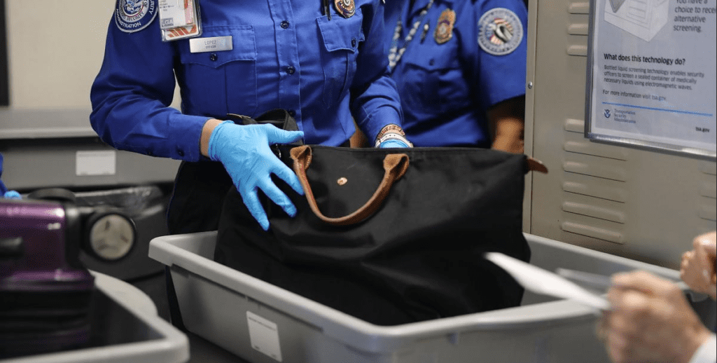 a police officer putting a bag in a plastic container