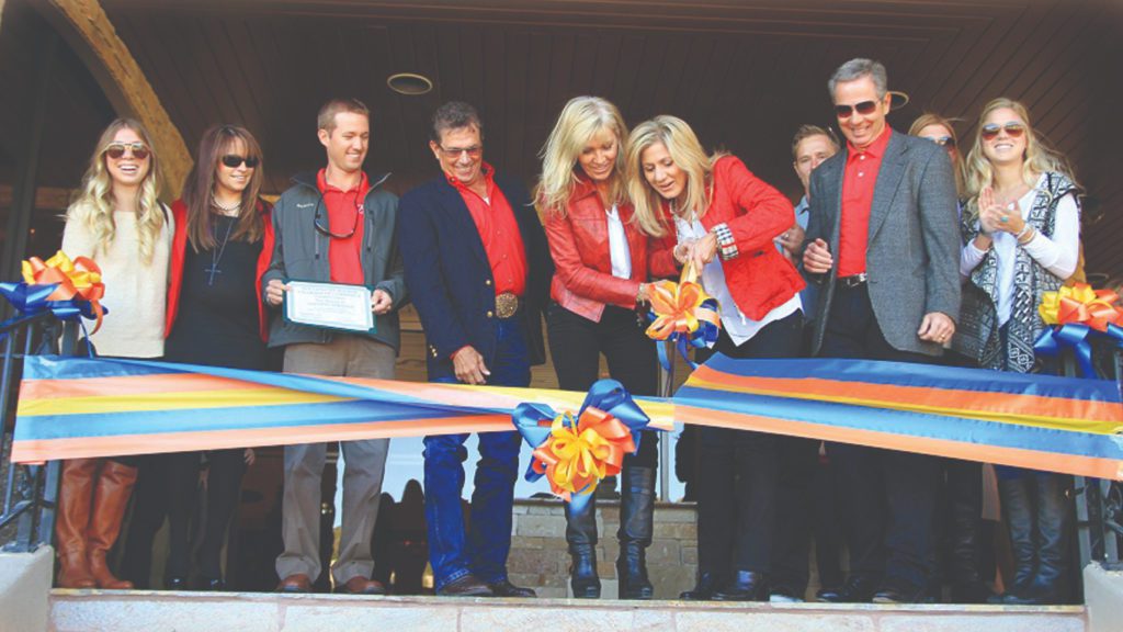 a group of people cutting a ribbon