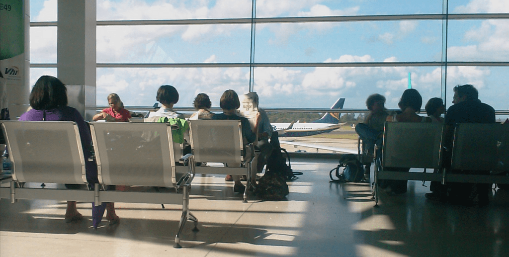 people sitting in chairs in an airport