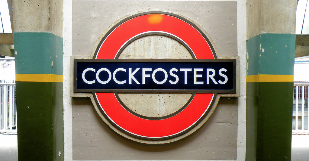 a sign on a wall with London Underground in the background