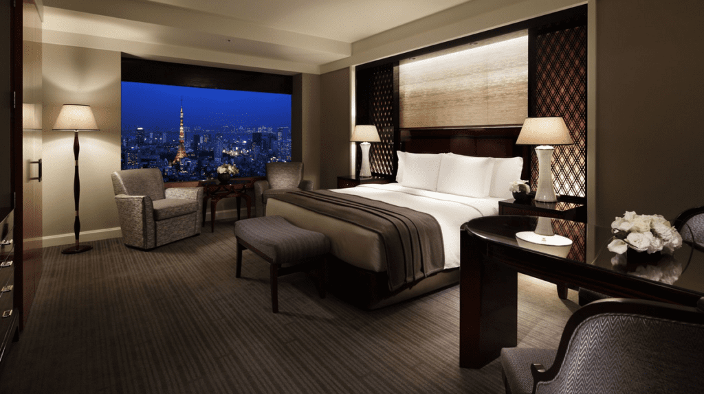 a room with a bed and a window with a city view