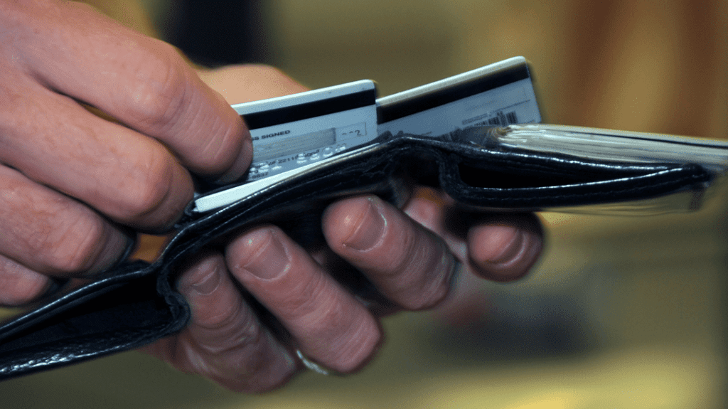 a person holding a wallet with credit cards