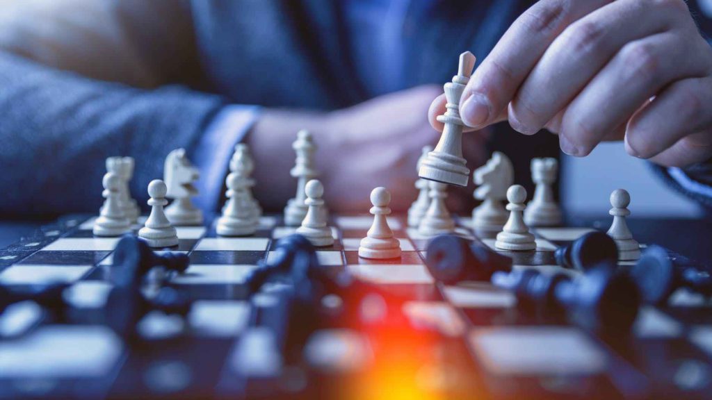 a person playing chess with a white piece