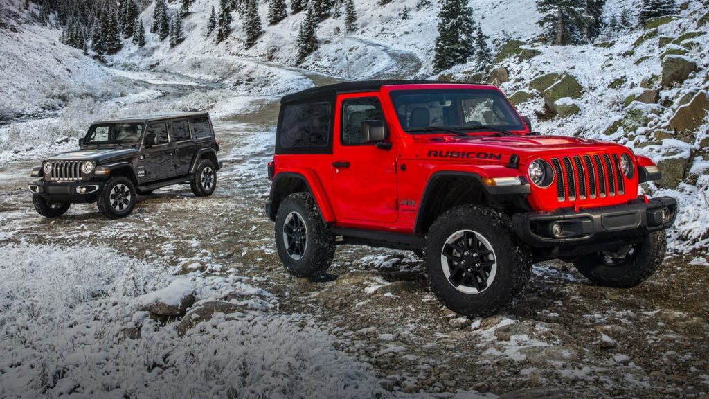 a red jeep parked on a snowy mountain