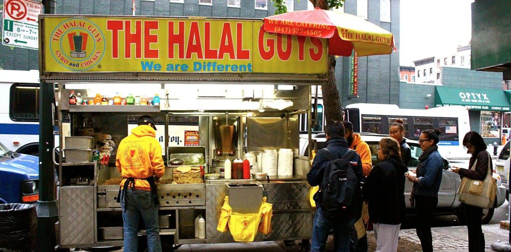 a group of people standing in front of a food truck