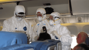 several people in protective gear on an airplane