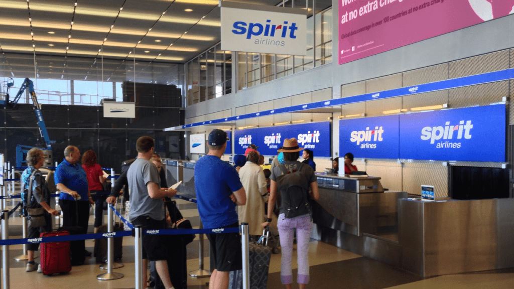 people standing in a line at an airport check in counter