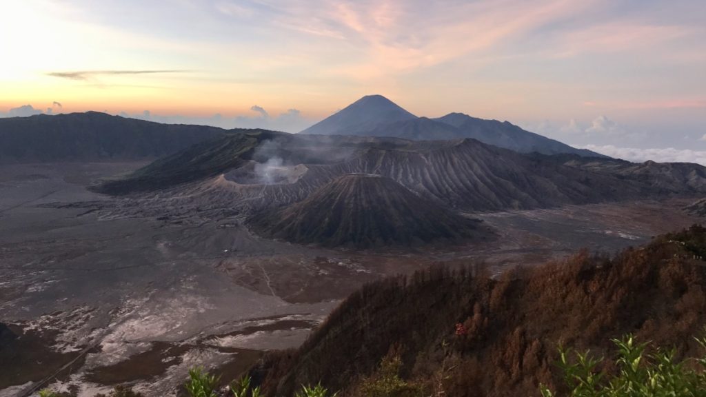 a mountain range with smoke coming out of the ground