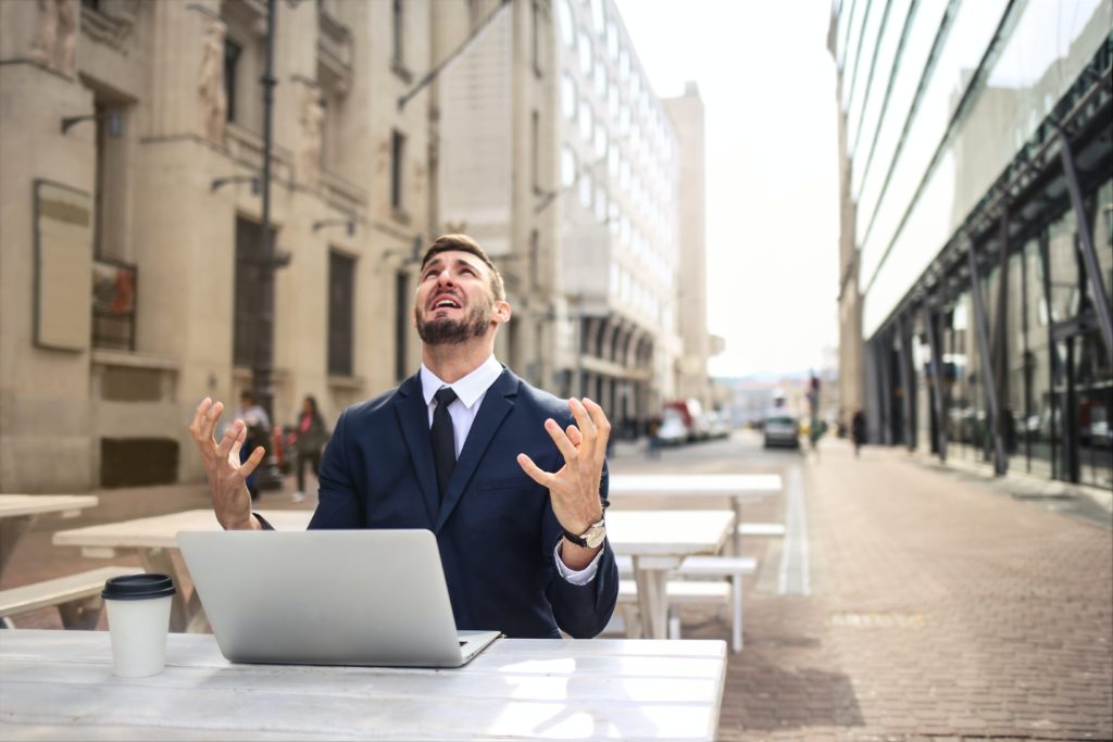 a man in a suit and tie sitting at a table with a laptop