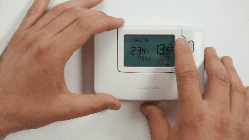 a person's hands on a thermostat