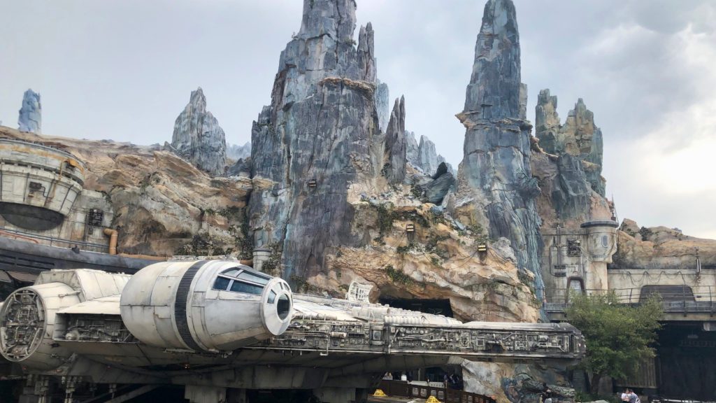 a space ship in front of a rocky mountain