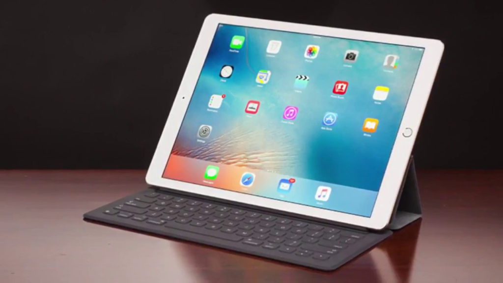 a white tablet with a keyboard on a wooden surface