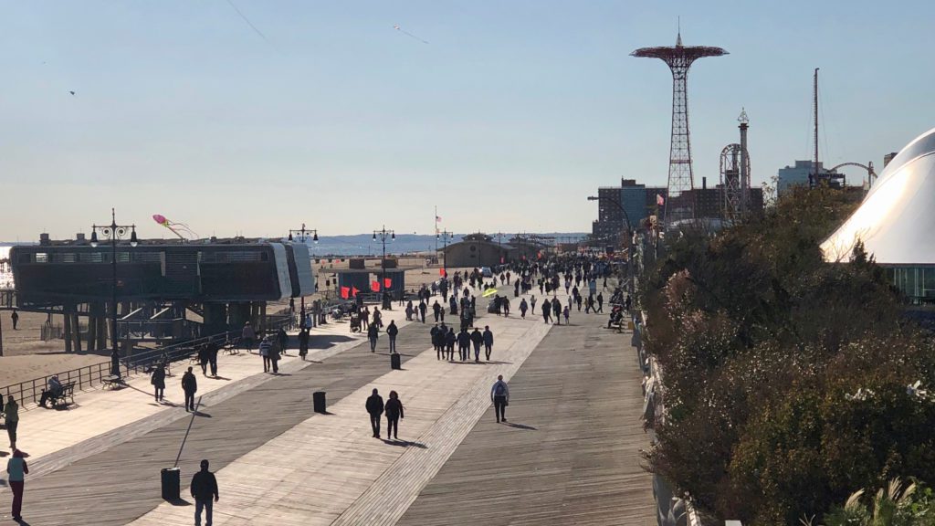 a group of people walking on a boardwalk