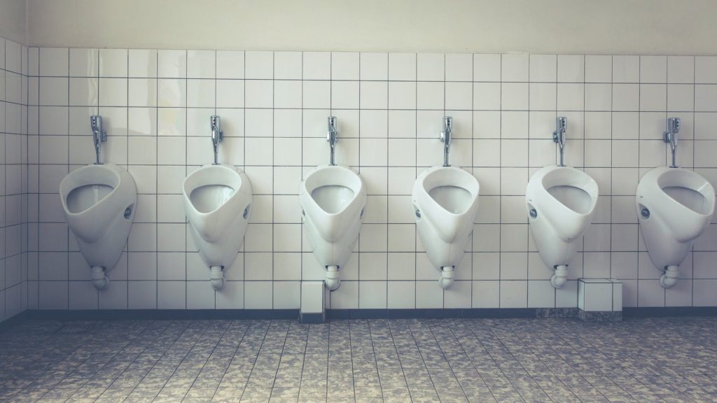 a row of urinals in a public bathroom