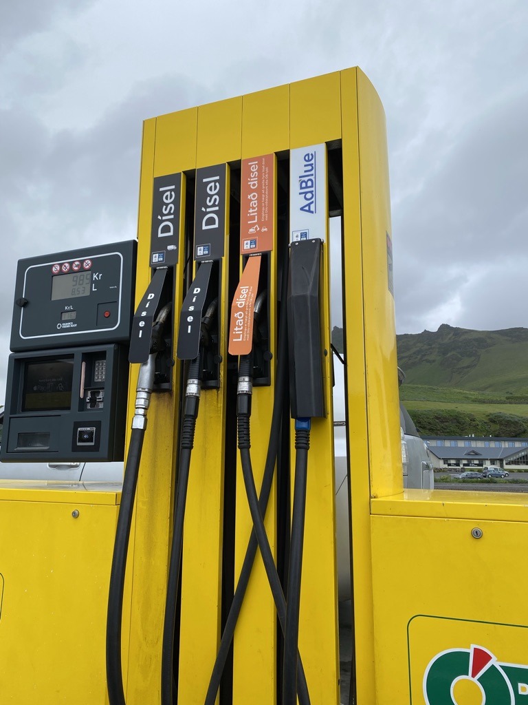 a yellow gas pump with nozzles